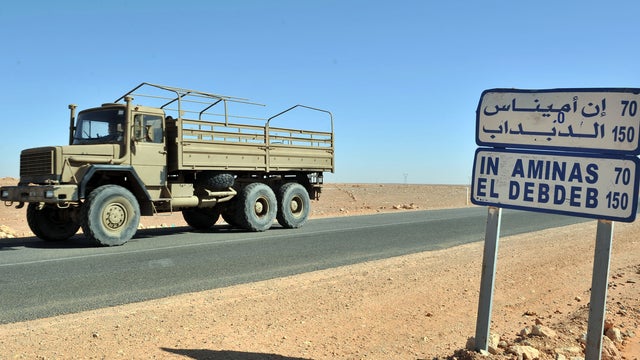 An Algerian military truck drives past a road sign indicating the city of Ain Amenas, Algeria, Jan. 18, 2013. 