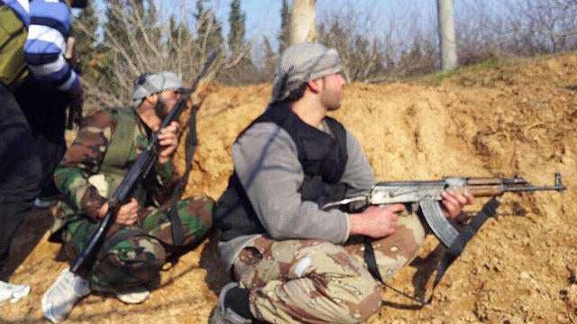 Syrian rebels take positions during clashes with government forces  