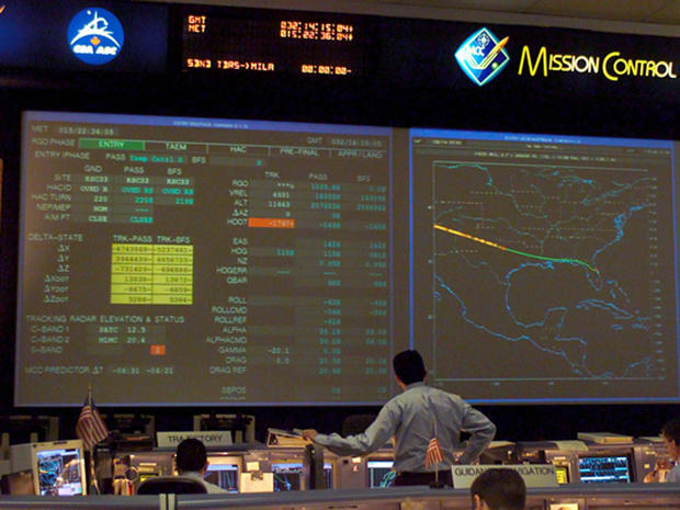 Mission control at the Johnson Space Center at roughly the time Columbia should have landed at the Kennedy Space Center. Numbers on the left screen are followed by an S, indicating a static display. The numbers stopped updating 15 minutes earlier when the shuttle veered out of control above central Texas. (CREDIT: NASA) 