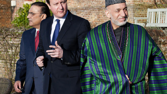 Britain's Prime Minister David Cameron (center) walks with Afghan President Hamid Karzai (right) and Pakistani President Asif Ali Zardari 