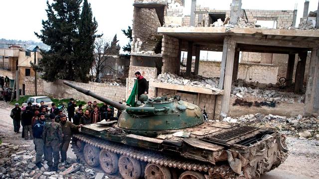 Syrian rebels gather around a T-72 tank, captured from government forces two months ago, in the village of Kfarruma in the flashpoint Syrian province of Idlib near the border with Turkey, on February 10, 2013. The rebels control large swathes of territory 