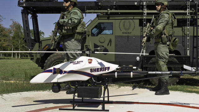 September 2011 photo provided by Vanguard Defense Industries shows ShadowHawk drone with Montgomery County, Texas, SWAT team members. the sheriffâ??s department there has a 50-pound ShadowHawk helicopter drone intended to supplement its SWAT team. 