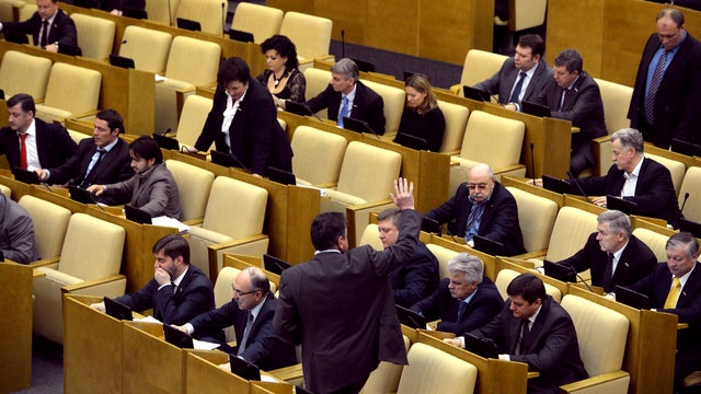 A lawmaker (bottom) signals to his fellow legislators to vote for a bill banning Americans from adopting Russian children in the lower house of Russia&acirc; 