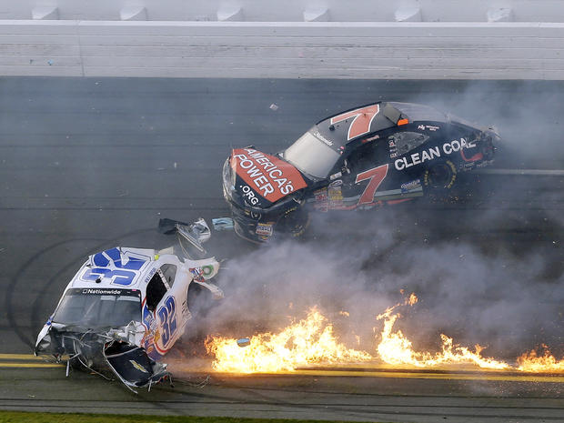Kyle Larson's car is on fire as he slides down the track with Regan Smith after being involved in a crash at the conclusion of the NASCAR Nationwide Series auto race Feb. 23, 2013, at Daytona International Speedway in Daytona Beach, Fla. 