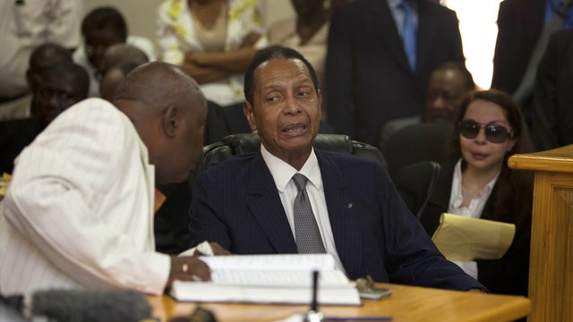 Former Haitian dictator Jean-Claude Duvalier, known as "Baby Doc," center, attends his hearing as his companion Veronique Roy sits behind, right, inside a courthouse in Port-au-Prince, Haiti, Thursday, Feb. 28, 2013.  