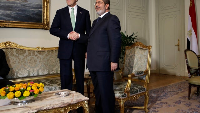 U.S. Secretary of State John Kerry, left, shakes hands with Egyptian President Mohamed Morsi at presidential palace in Cairo, Egypt on March 3, 2013 
