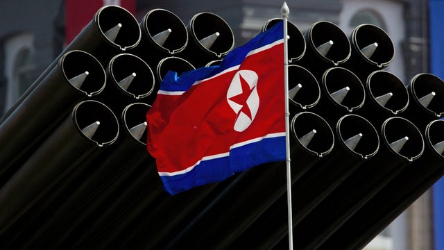 North Korean flag flies before missiles displayed during a military parade to mark 100 years since the birth of the country's founder Kim Il-Sung in Pyongyang on April 15, 2012. The commemorations came just two days after a satellite launch timed to mark  