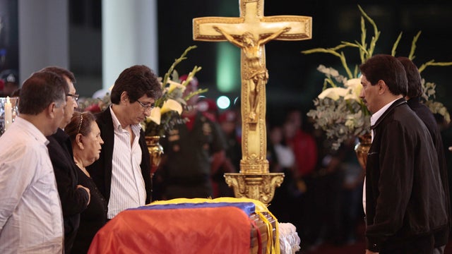 In photo released by Miraflores Press Office, Hugo Chavez' mother, Elena Frias, third from left, and brothers stand on Wednesday, March 6, 2013 next to flag-draped coffin containing body of Venezuela's late president, on display during his wake at militar 
