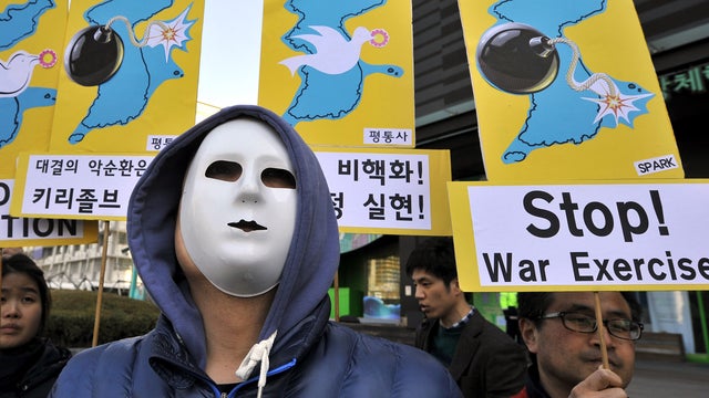 Anti-war activists wearing masks hold placards showing the Korean Peninsula during a protest against a joint military exercise between South Korea and the U.S., called Key Resolve, near the U.S. embassy in Seoul on March 11, 2013. 