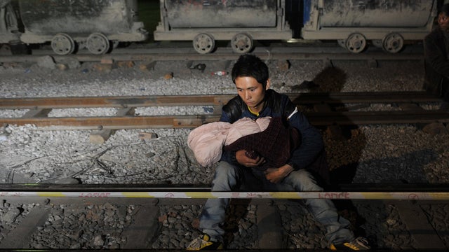 Photo provided by China's Xinhua News Agency shows relative of miners waiting at site of accident in Shuicheng County, southwest China's Guizhou Province, on March 13, 2013 