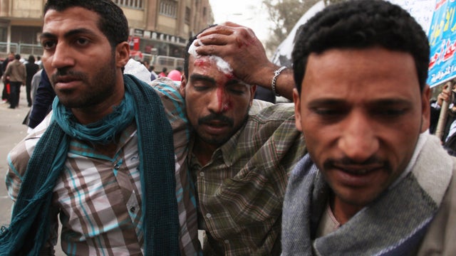 A wounded man is escorted as opponents and supporters of Egypt&acirc;??s Muslim Brotherhood clash near the Islamist group&acirc;??s Cairo headquarters on March 22, 2013.  