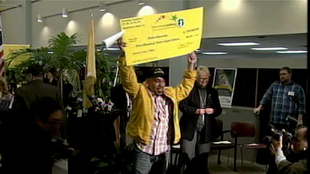 Pedro Quezada holds up his $338 million Powerball jackpot check on Tuesday, March 26. 