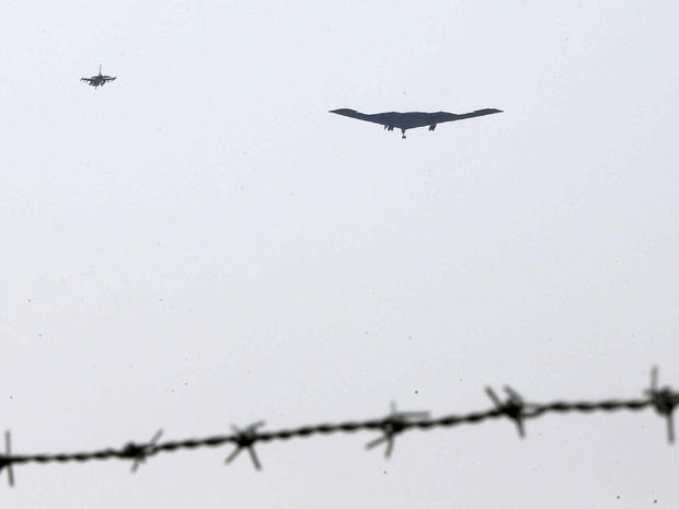U.S. Air Force B-2 stealth bomber, center, flies over near the Osan U.S. Air Base in Pyeongtaek, south of Seoul, South Korea, March 28, 2013. 