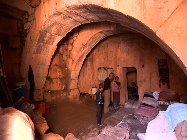 Syrians stand inside their cave home in Jabel Zawiya's "Dead Cities" 