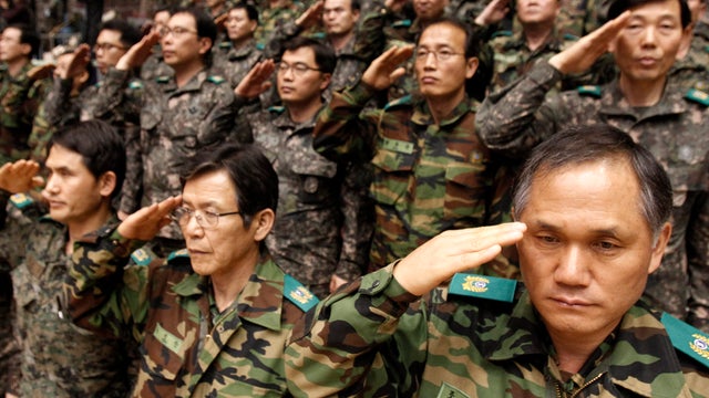 South Korean army reservists salute during their Foundation Day ceremony at a gymnasium in Seoul, South Korea, April 5, 2013. 