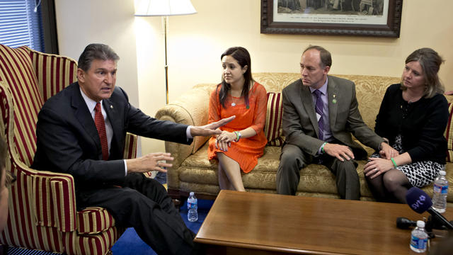 Sen. Joe Manchin, D-W.Va., left, meets in his office with families of victims of the Sandy Hook Elementary School shooting in Newtown, Conn., on the day he announced that he reached a bipartisan deal on expanding background checks to more gun buyers, on C 