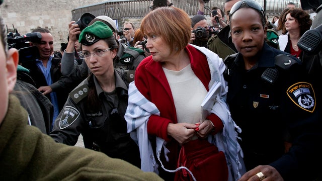 An Israeli woman is arrested for wearing a prayer shawl at the Western Wall in Jerusalem on April 11, 2013. 