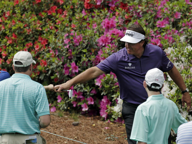 Phil Mickelson touches a young spectator's fist as he walks down the sixth fairway during the second round of the Masters golf tournament April 12, 2013, in Augusta, Ga. 