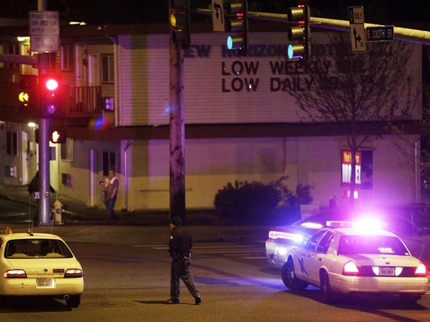 A Washington State Patrol trooper directs a driver away from a street blocked off several blocks from the scene of an overnight shooting that police said left five people dead, Monday, April 22, 2013, at an apartment complex in Federal Way, Wash. 