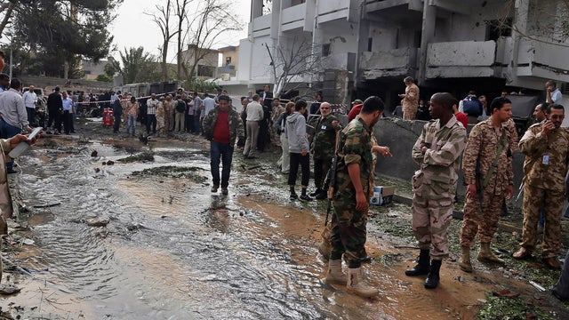 Security personnel inspect the site of a car bomb that targeted the French embassy wounding two French guards and causing extensive material damage in Tripoli, Libya, Tuesday, April 23, 2013.  