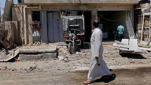Civilians inspect the aftermath of a car bomb attack in the Husseiniyah area of northeastern Baghdad, Iraq, Thursday, April 25, 2013. A car bomb exploded after sunset on Wednesday, April 24, 2013 near a bus stop in Baghdad's mostly Shiite neighborhood of  