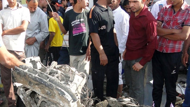 Iraqis inspect site of car bomb explosion in Diwaniyah, south of Baghdad, on April 29, 2013. 