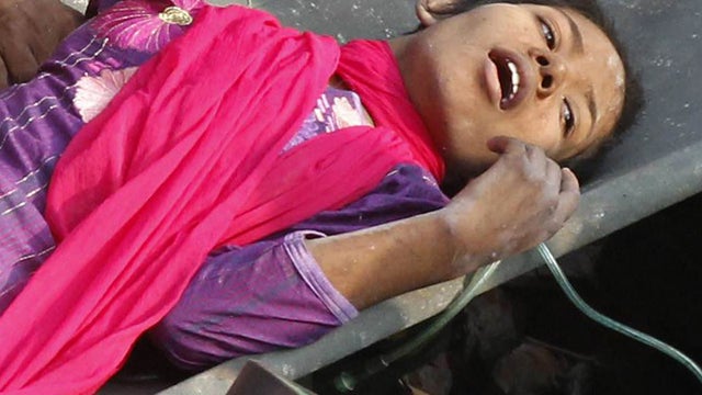 Bangladeshi rescuers retrieve garment worker Reshma from the rubble of a collapsed building in Savar on May 10, 2013, 17 days after the eight-story building collapsed. 