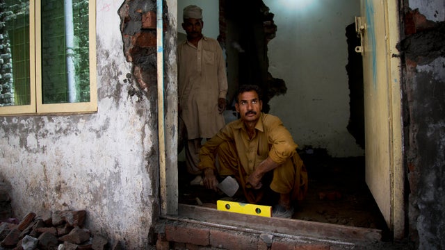 A Pakistani Christian repairs his home, damaged by mobs of radical Muslims in the Joseph Colony 