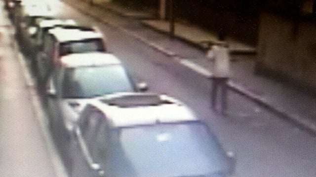 A man identified as Kabobo Mada, 21, from Ghana, walks holding a pickaxe on his back in this surveillance camera framegrab made available May 11, 2013, by Italian Carabinieri paramilitary police. 