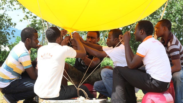 In this photo dated Tuesday, May 14, 2013, students prepare the balloon that will be used to conduct a test launch of a Coke-can sized satellite, at All Nations University in Koforidua, Ghana.  