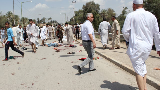Iraqis gather at the scene of a bomb attack in Baqouba 