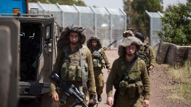 Israeli soldiers patrol next to the fence on the border with Syria in the Israeli-annexed Golan Heights 