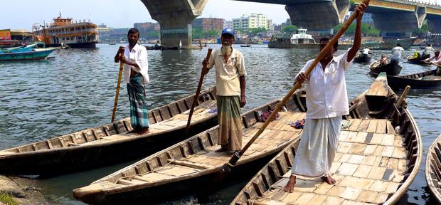 Boatmen stand on their vessels in the Buriganga River in Dhaka, the capital of Bangladesh 