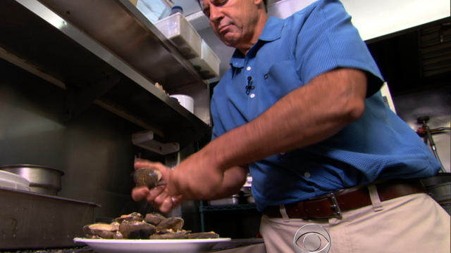 Mike Garofalo, co-owner of the Harvey Cedars Shellfish Company on Long Beach Island, N.J., shucks clams May 24, 2013. 