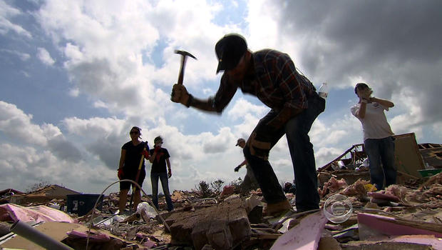 Joe Mallo digs through the rubble of a tornado-ravaged house in Moore, Okla. 
