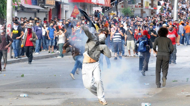 	A protestor throws a tear gas canister back at riot police as he takes part in a demonstration in support of protests in Istanbul and against the Turkish Prime Minister and his ruling Justice and Development Party (AKP), in Ankara, on June 2, 2013.  