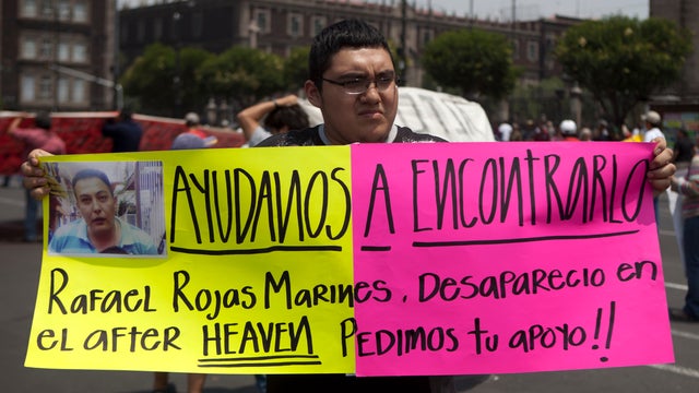 A man holds up a sign with details of his recently disappeared relative during a protest in Mexico City 