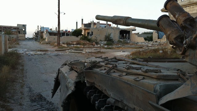Syrian army troops in a tank patrol the ruined streets of Dabaa, north of Qusayr 
