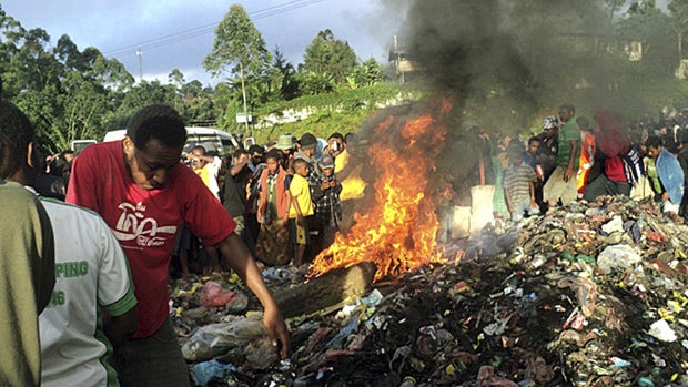 In this Feb. 6, 2013 file photo, hundreds of bystanders watch Helen Rumbali, a woman accused of witchcraft, being burned alive in the Western Highlands provincial capital of Mount Hagen in Papua New Guinea.  