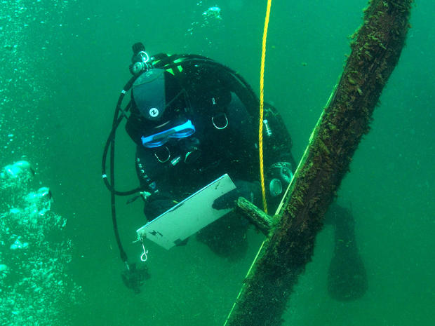 French underwater archaeologist Olivia Hulot jots notes while inspecting a timber jutting from the bottom of northern Lake Michigan. 