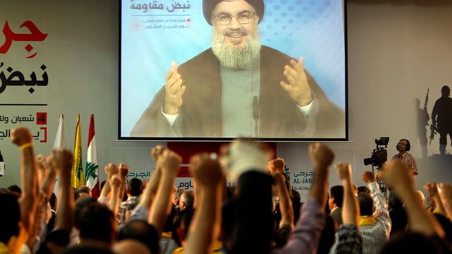 Supporters of Hezbollah watch the group's leader give an address 