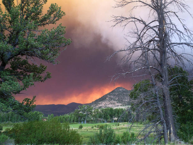 In this June 20, 2013, photo provided by the U.S. Forest Service, wildfires fires approach the town of South Fork, Colo. 