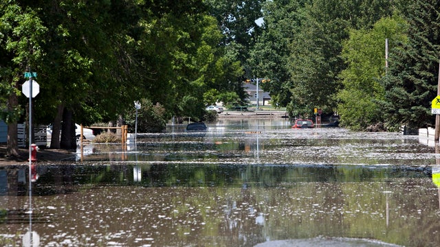 Cars are partially submerged as water recedes from a street in High River, Alberta, Canada, June 22, 2013, after the Highwood River overflowed its banks. 