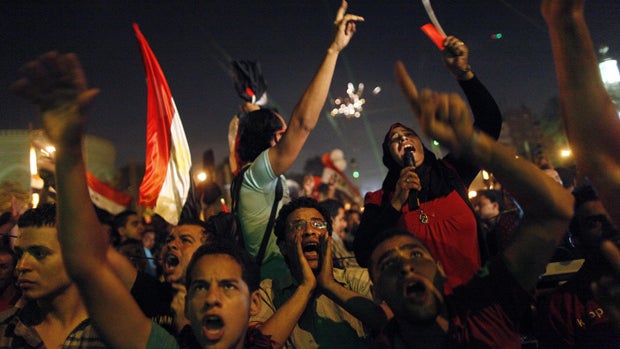 Egyptian protesters calling for the ouster of President Mohamed Morsi react as they watch his speech on a screen in a street leading to presidential palace early in Cairo on July 3, 2013. Morsi told Egyptians that he had been freely elected little more th 
