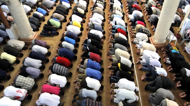 Jordanians and Syrian refugees pray in the Ramtha Grand Mosque, on the first day of the holy month of Ramadan, in Ramtha, Jordan, near the border with Syria, Friday, July 20, 2012.  