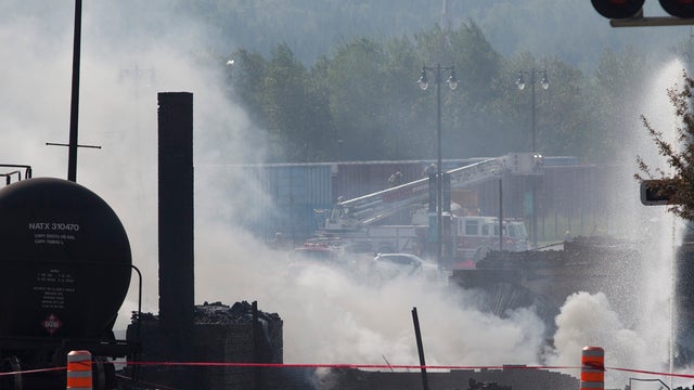 Wreckage continues to burn on July 7, 2013 after freight train loaded with oil derailed July 6 in Lac-Megantic in Canada's Quebec province, sparking explosions that engulfed about 30 buildings in a wall of fire 