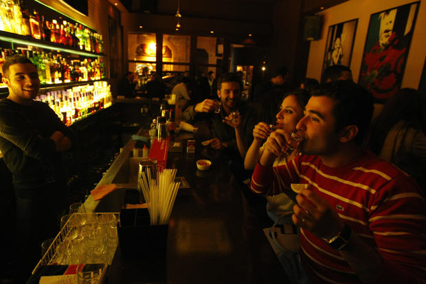 Lebanese men and women drink at a bar in 