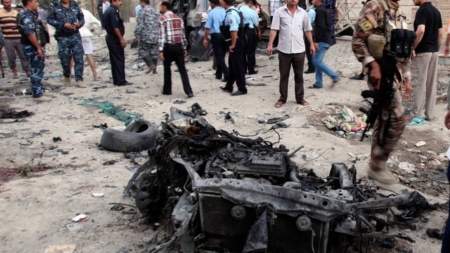 Security forces inspect the scene of a car bomb attack in Basra, 340 miles southeast of Baghdad 