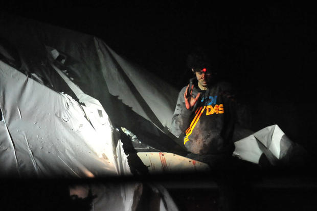 Dzhokhar Tsarnaev emerges from a boat he was hiding in in Watertown, Mass., following a nearly 24-hour-long manhunt with authorities on April 19, 2013. 