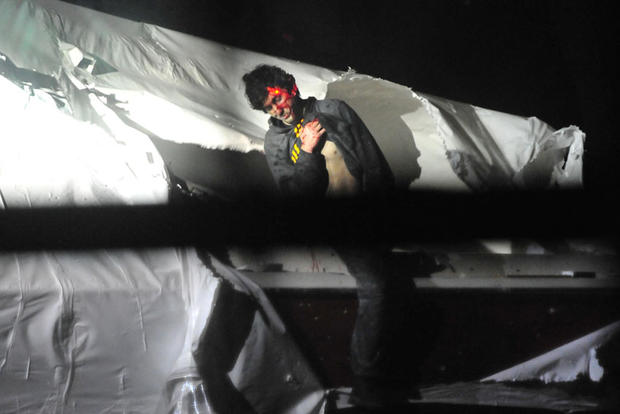 Dzhokhar Tsarnaev emerges from the boat he was hiding in in Watertown, Mass. 